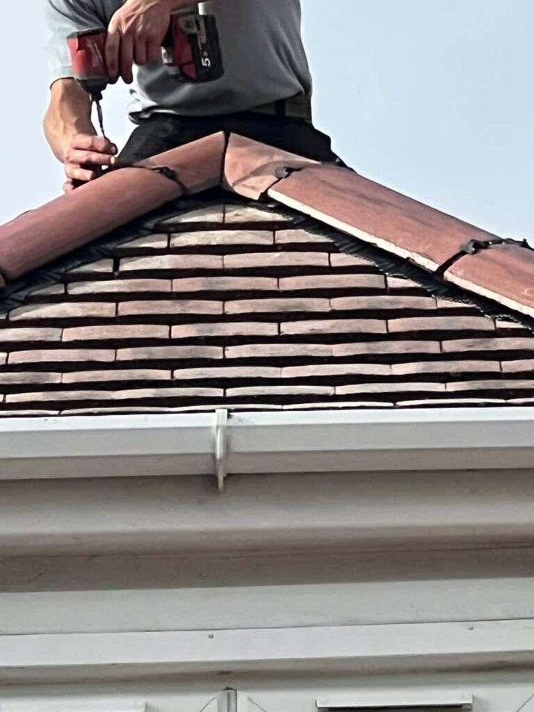 This is a photo of one of the operatives of Godstone Roofing Repairs installing new ridge tiles